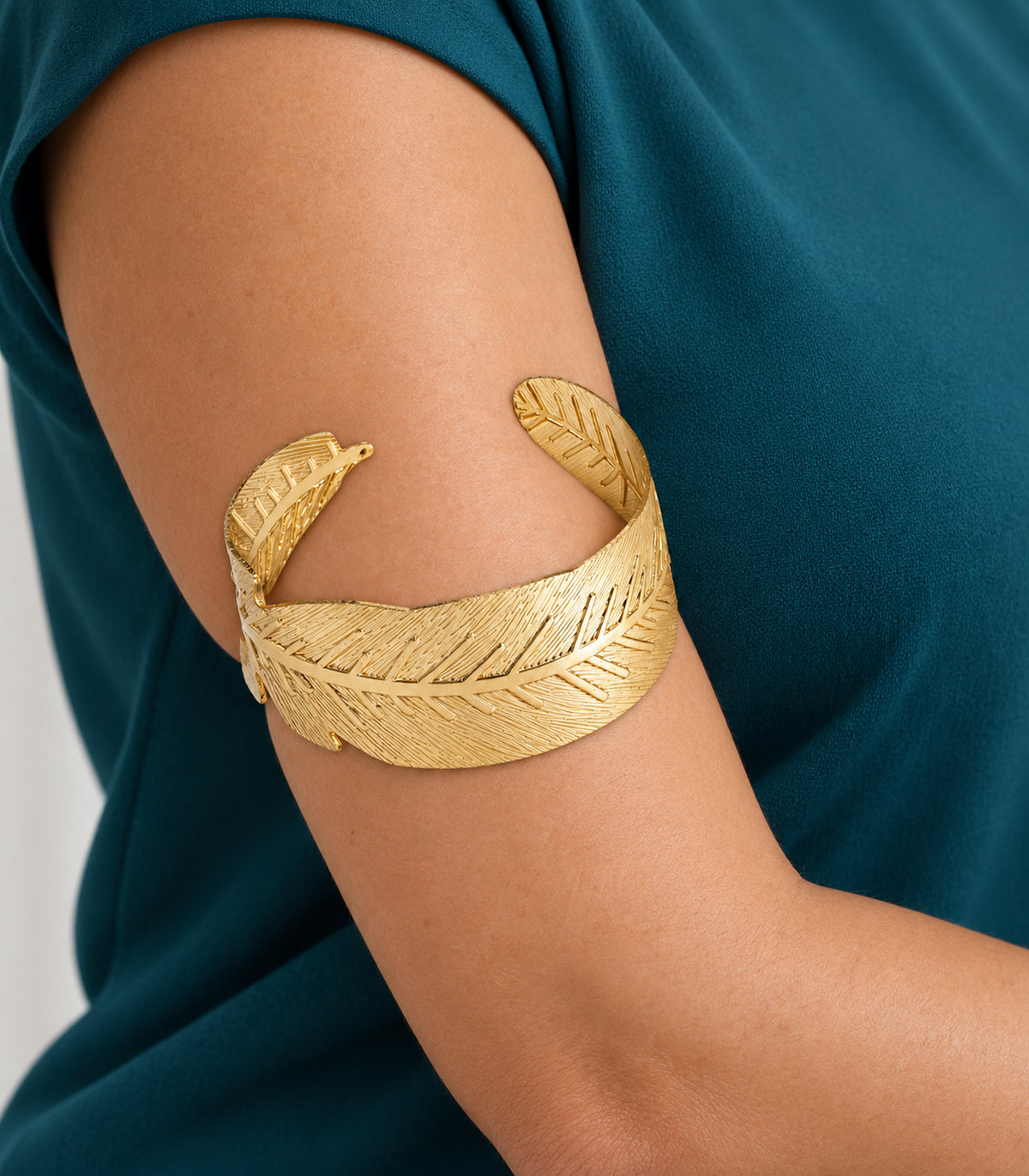 Close view of the gold tone leaf arm cuff and engraved veins worn on the upper arm