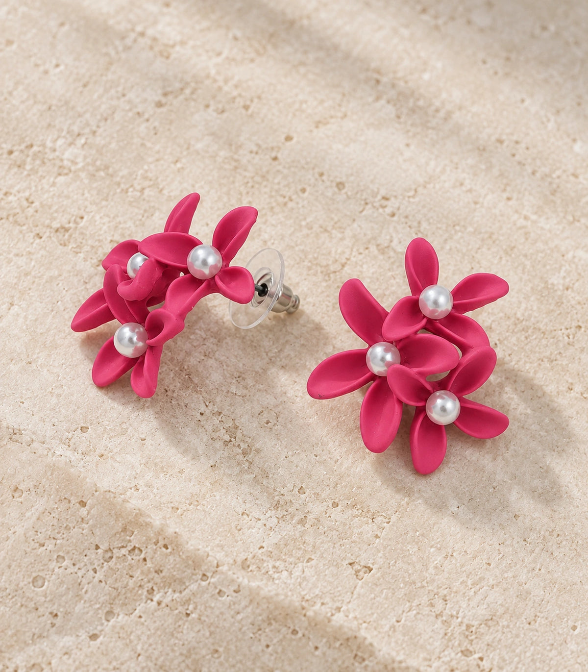 JIMIKI Hot Pink cascading floral cluster stud earrings, matching pair styled on a light textured surface #color_hot pink