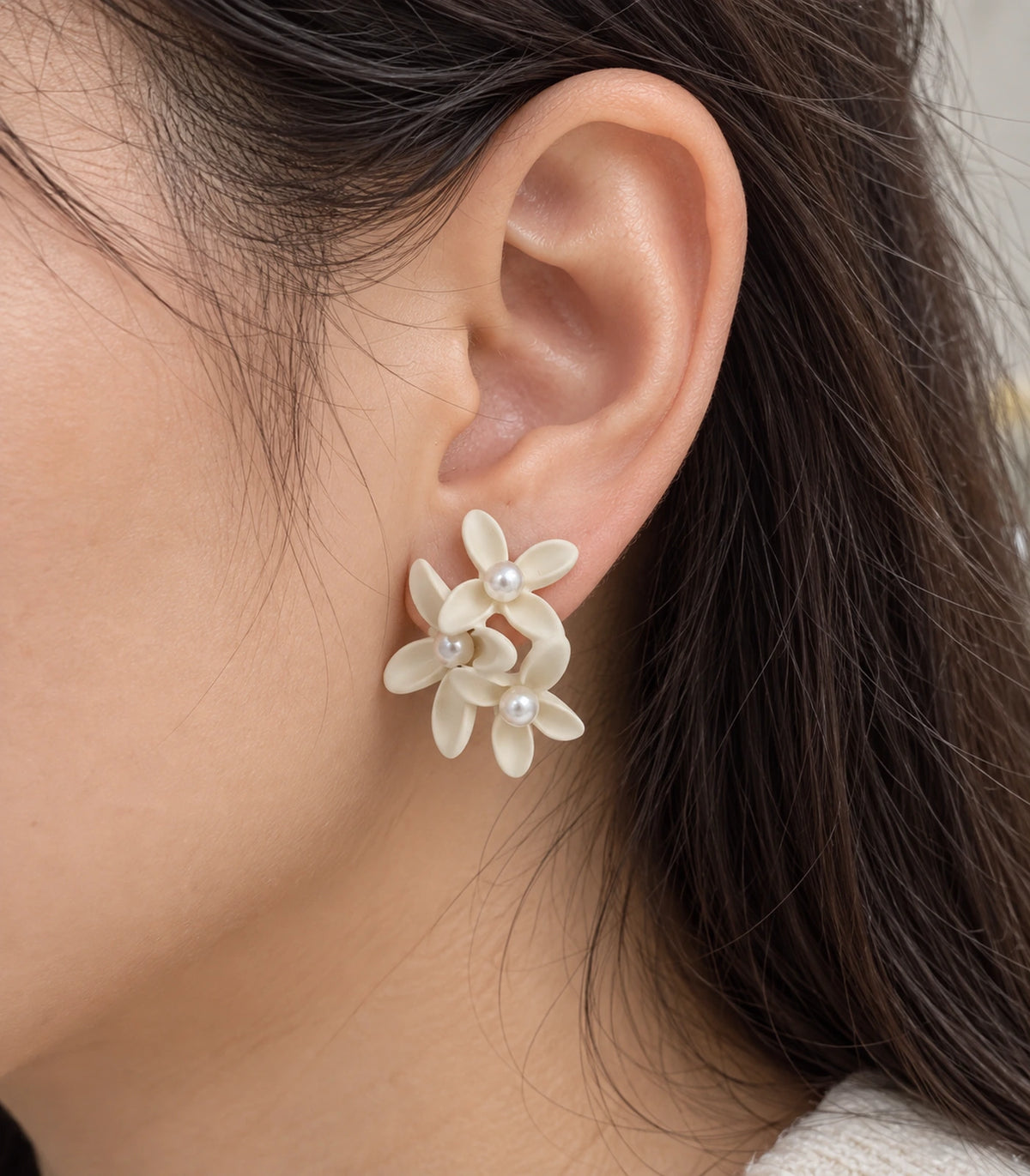 JIMIKI Ivory cascading floral cluster stud earrings, close-up of the three pearl-like centres and curved petals #color_ivory