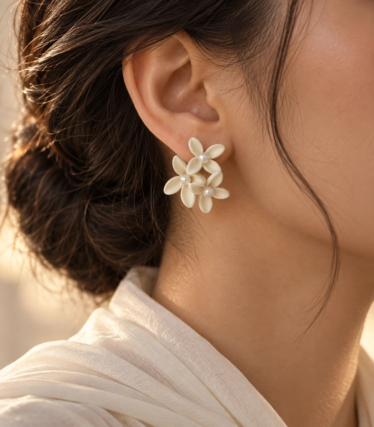 JIMIKI Ivory cascading floral cluster stud earrings, worn with softly lit editorial styling #color_ivory