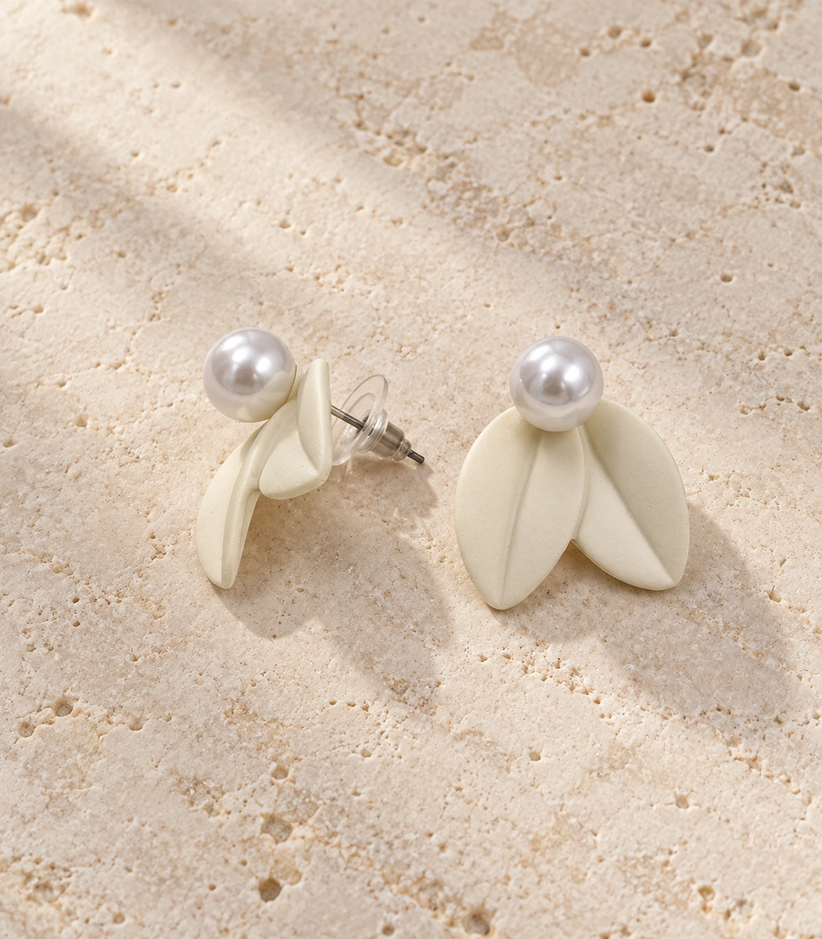 JIMIKI Double Leaf Pearl Stud Earrings in Ivory — pair in a styled flat lay #color_ivory