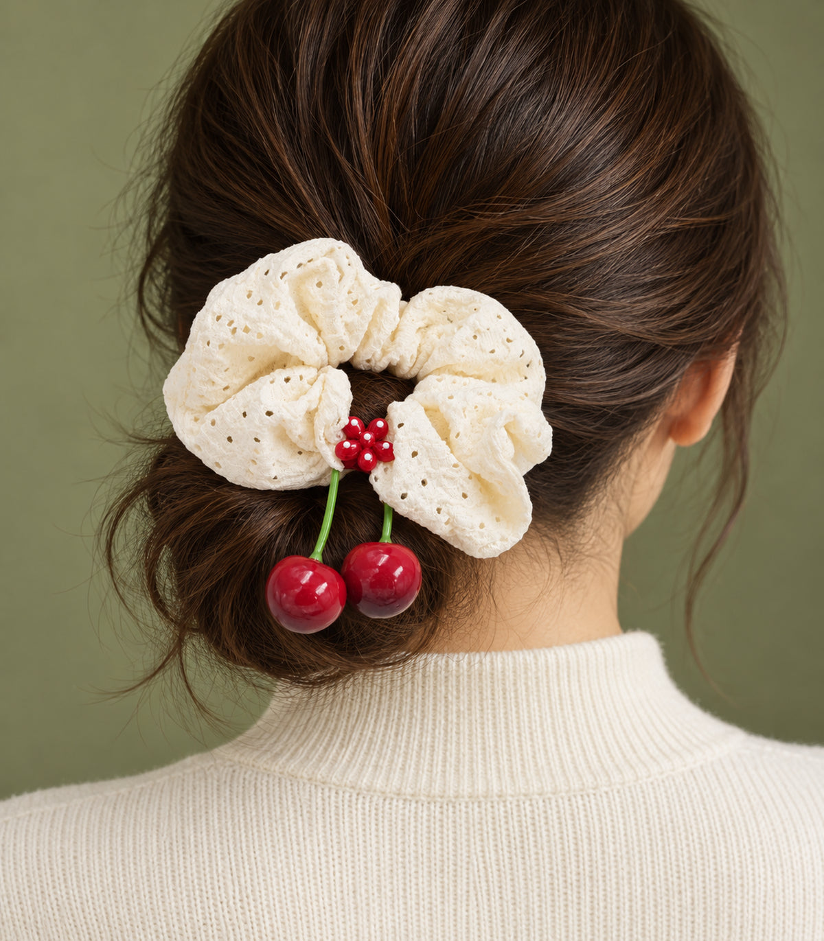 Ivory eyelet cherry scrunchie with dotted red flower centre — editorial model view
