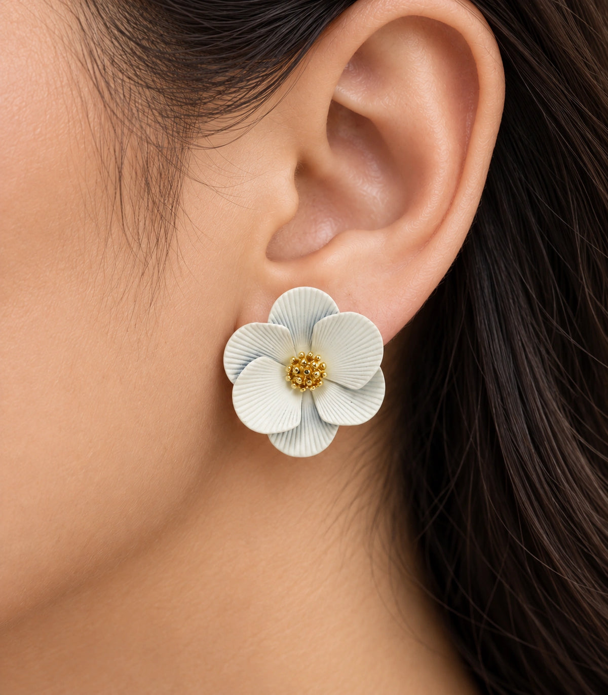 JIMIKI Ivory ribbed flower stud earrings, worn closeup of ribbed petals and gold-tone centre #color_ivory