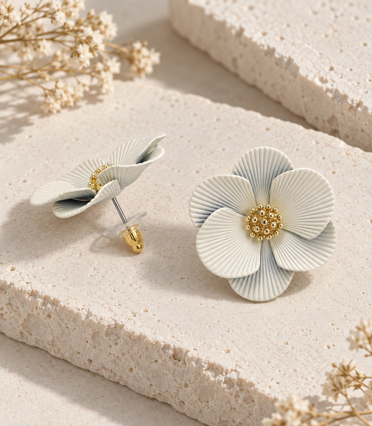 JIMIKI Ivory ribbed flower stud earrings, pair arranged in an editorial flat lay #color_ivory