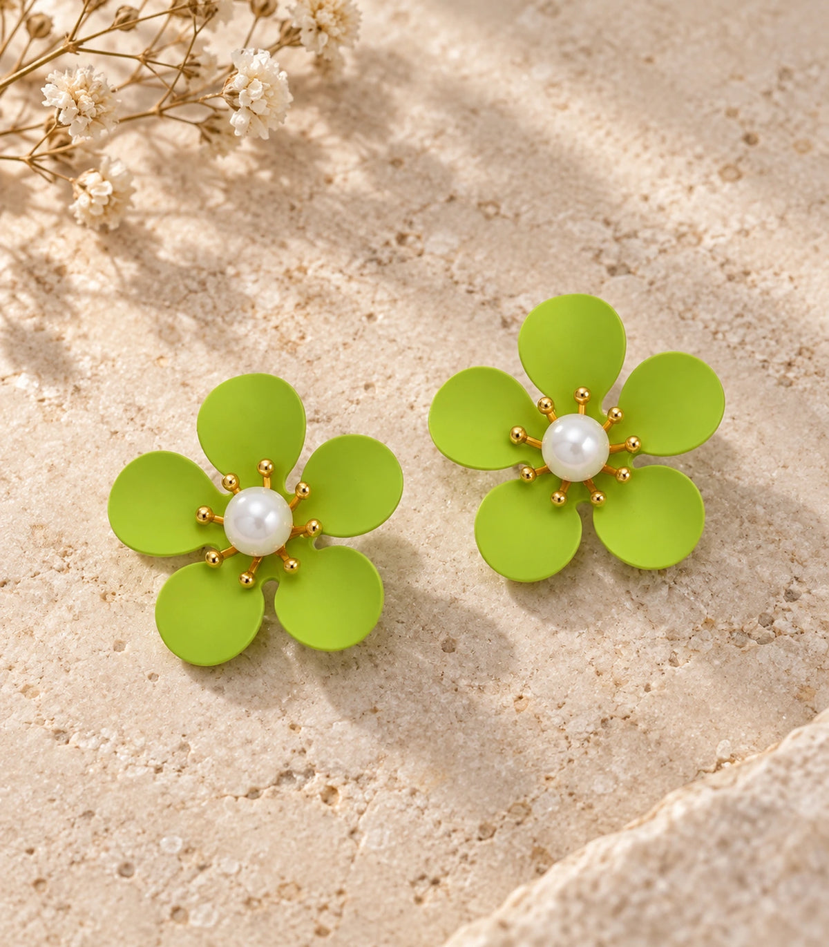 JIMIKI lime five-petal flower stud earrings with pearl-effect centre, matching flower stud pair in an editorial flat lay #color_lime