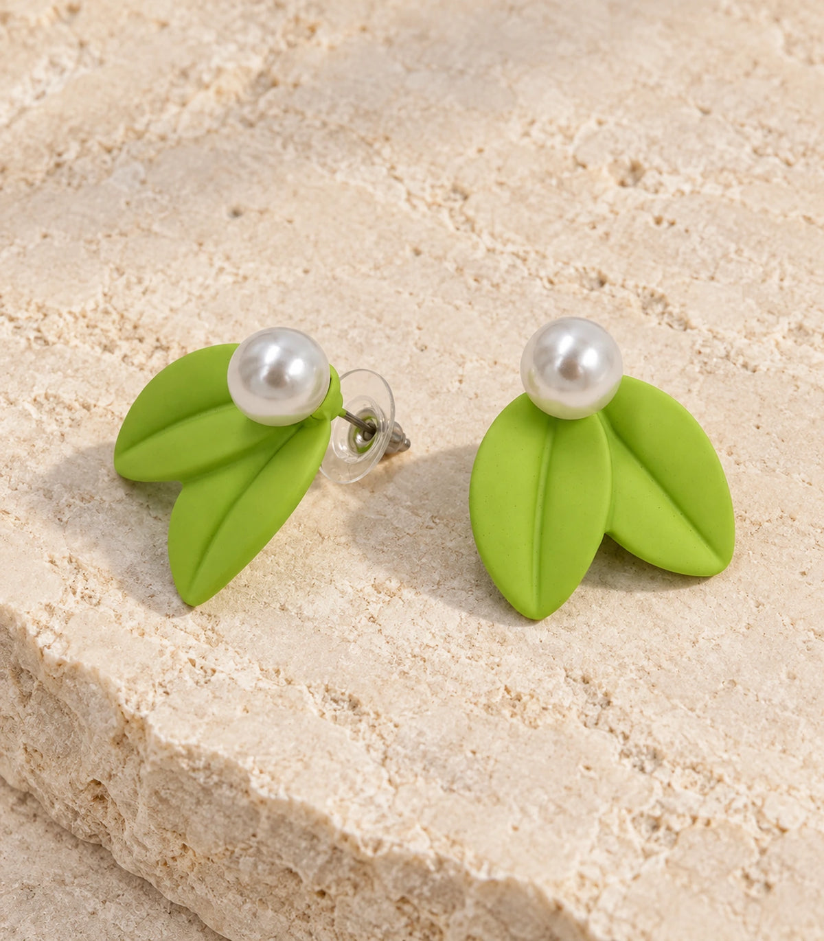 JIMIKI Double Leaf Pearl Stud Earrings in Lime Green — pair in a styled flat lay #color_lime green