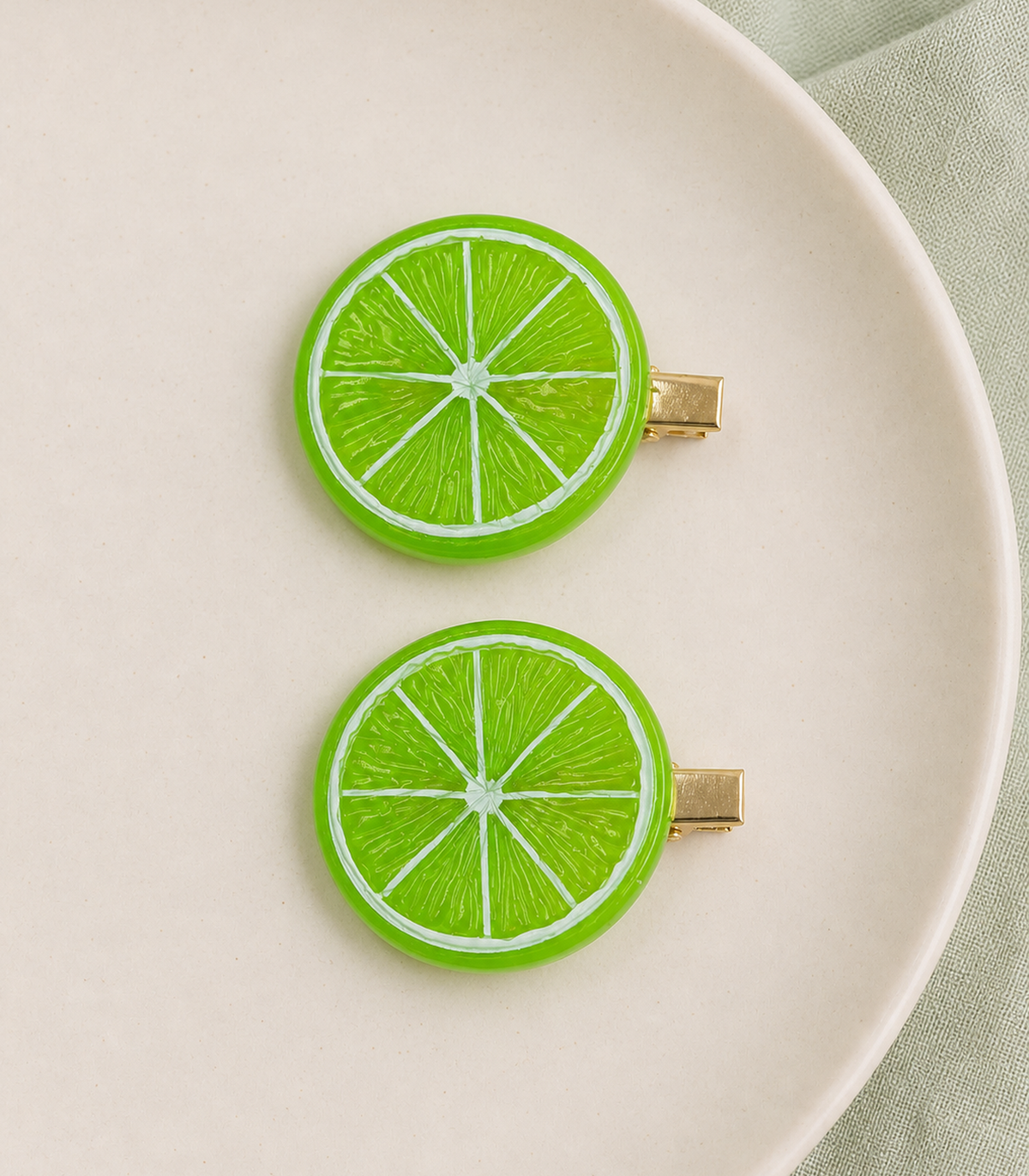 JIMIKI Bright Green Lime Slice Barrette Pair in Lime Green, editorial flat lay