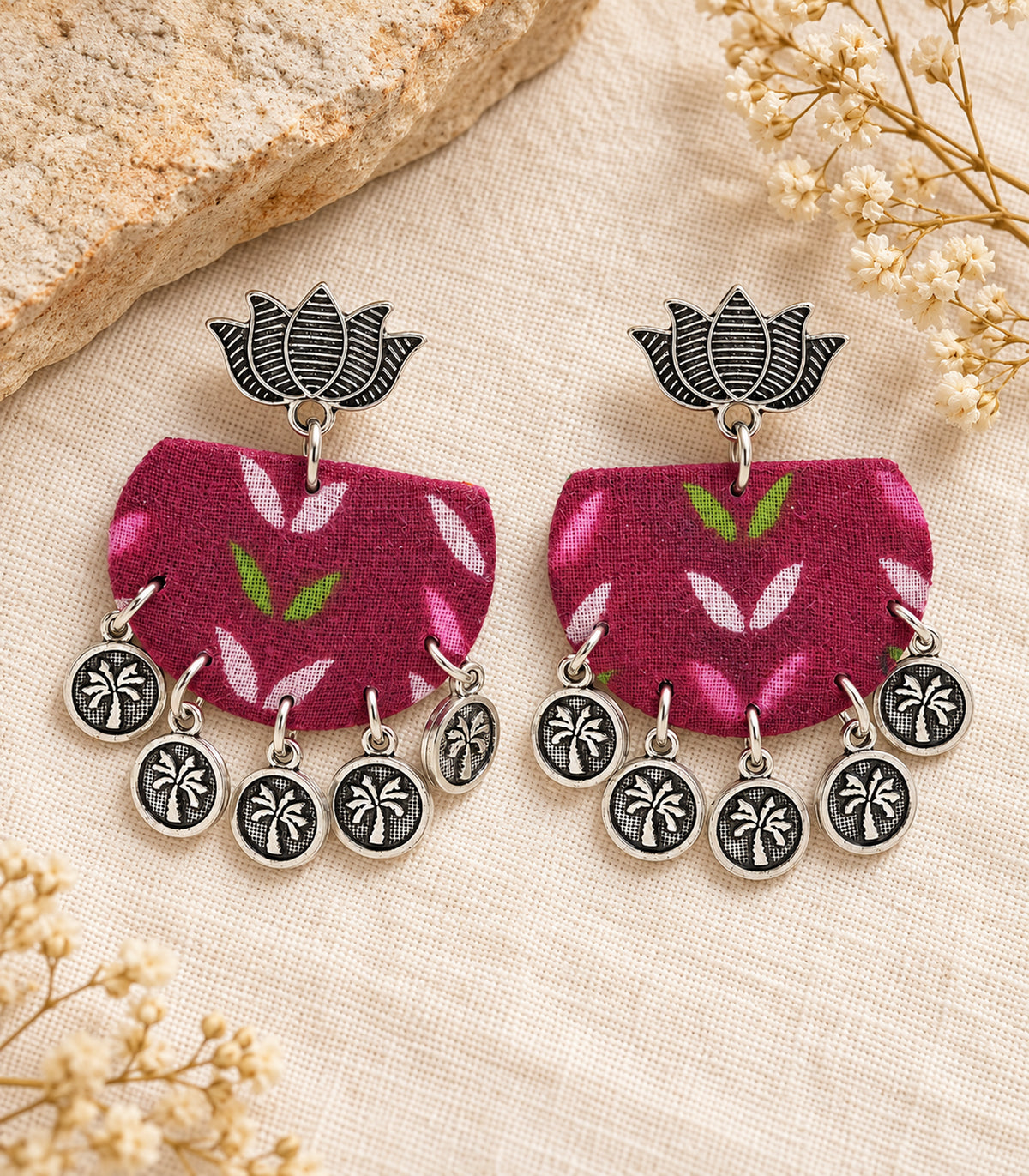 Magenta leaf fabric lotus coin earrings — complete pair in an editorial flatlay