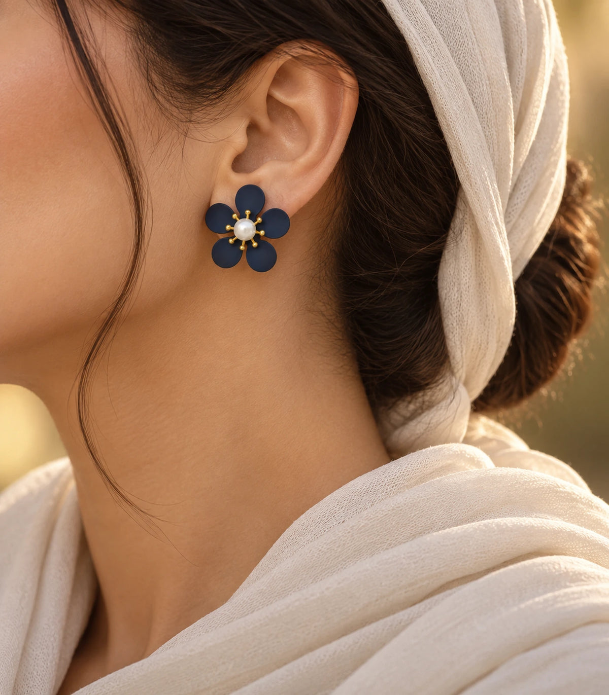 JIMIKI navy five-petal flower stud earrings with pearl-effect centre, alternate styled worn view of flower stud #color_navy