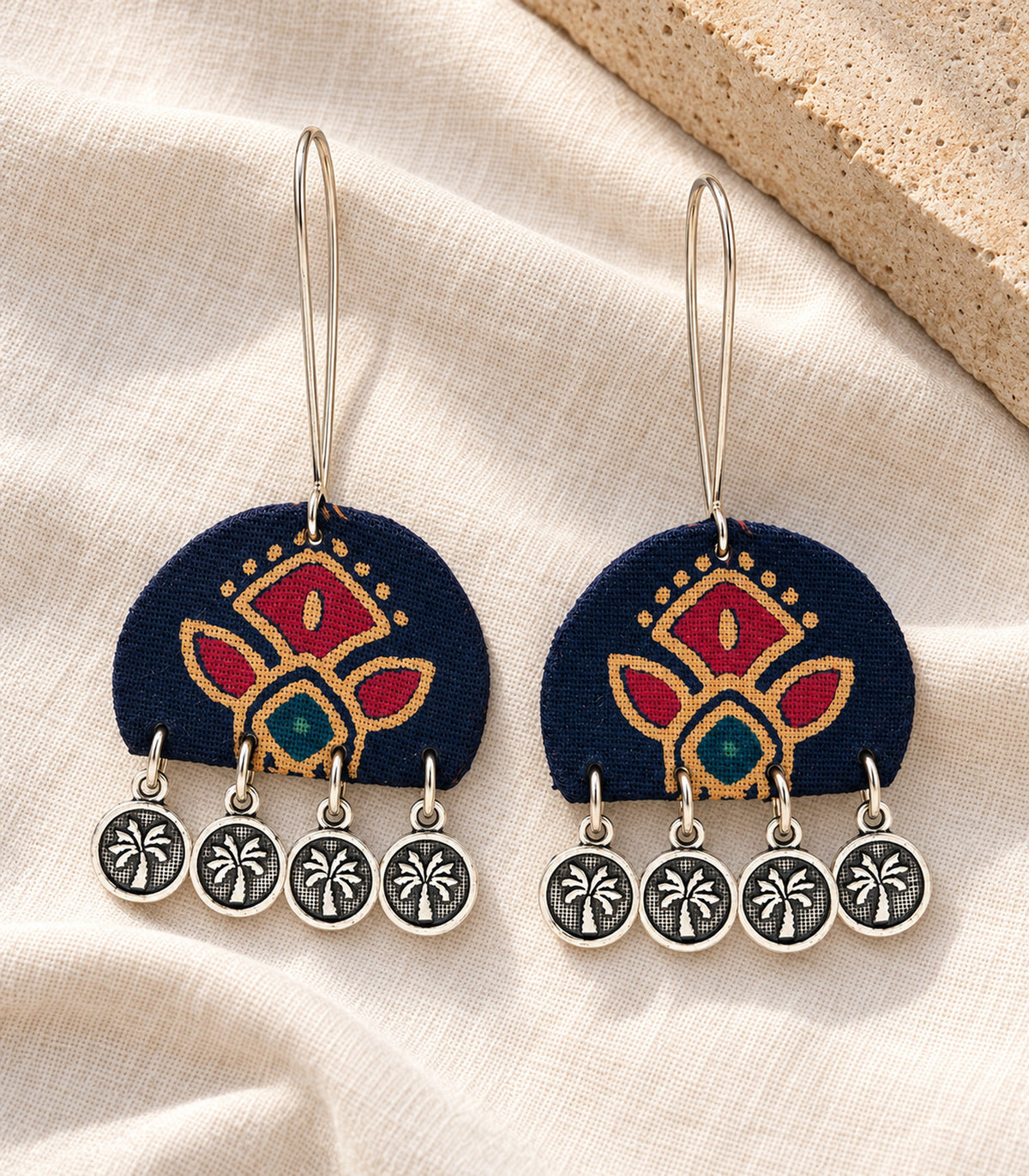 Pair of navy floral fabric four-coin earrings on ivory linen