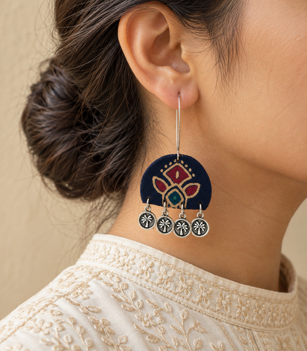 Navy floral four-coin earring in an ivory editorial worn composition