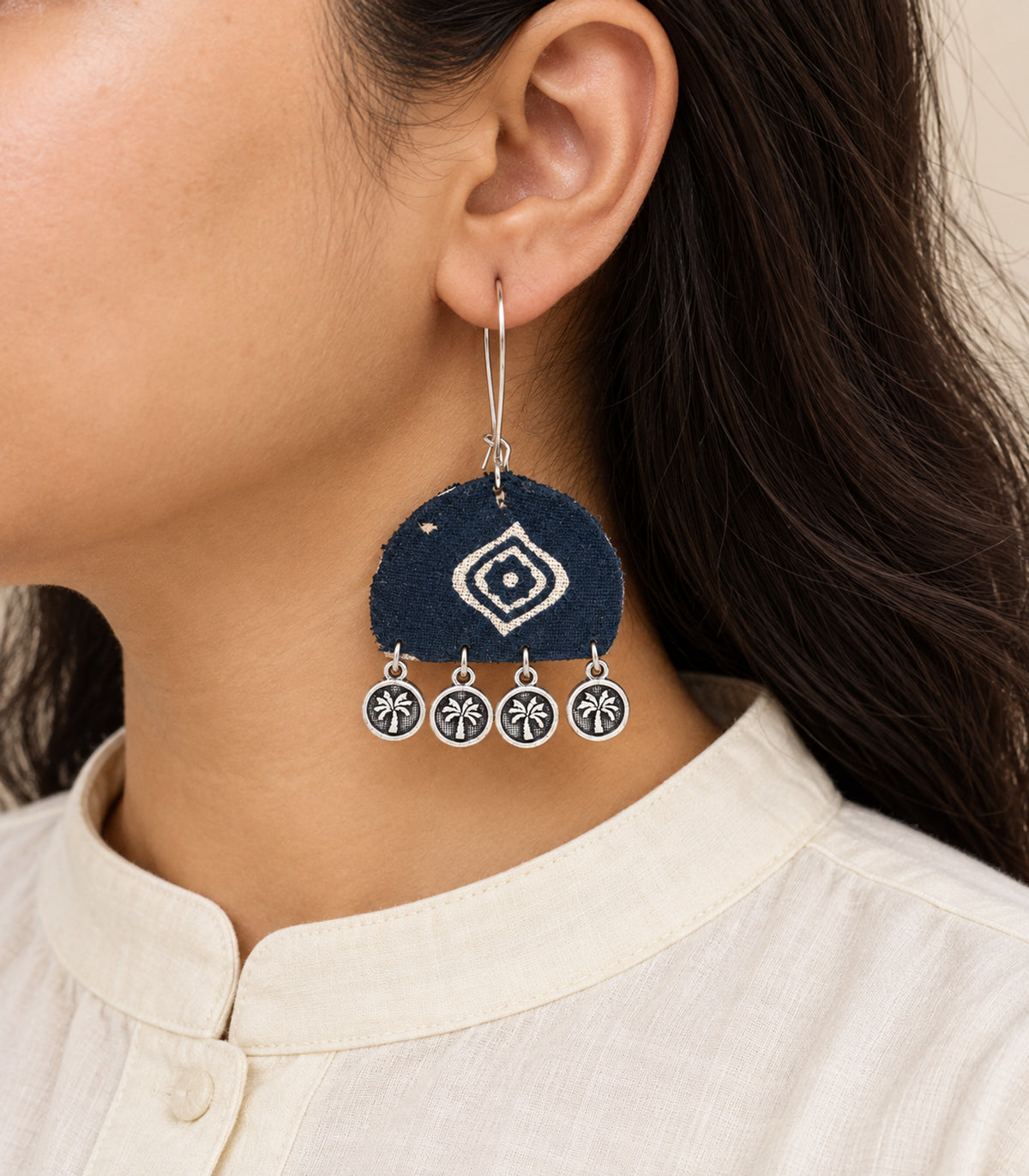 Navy and ivory diamond motif coin earrings — closeup view