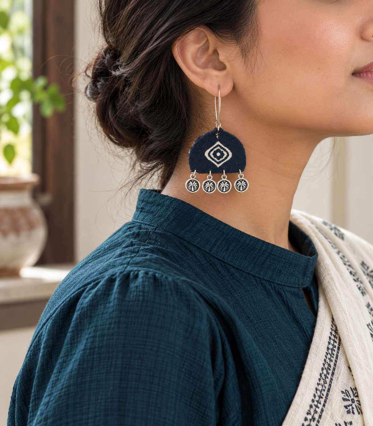 Navy and ivory diamond motif coin earrings — editorial model view