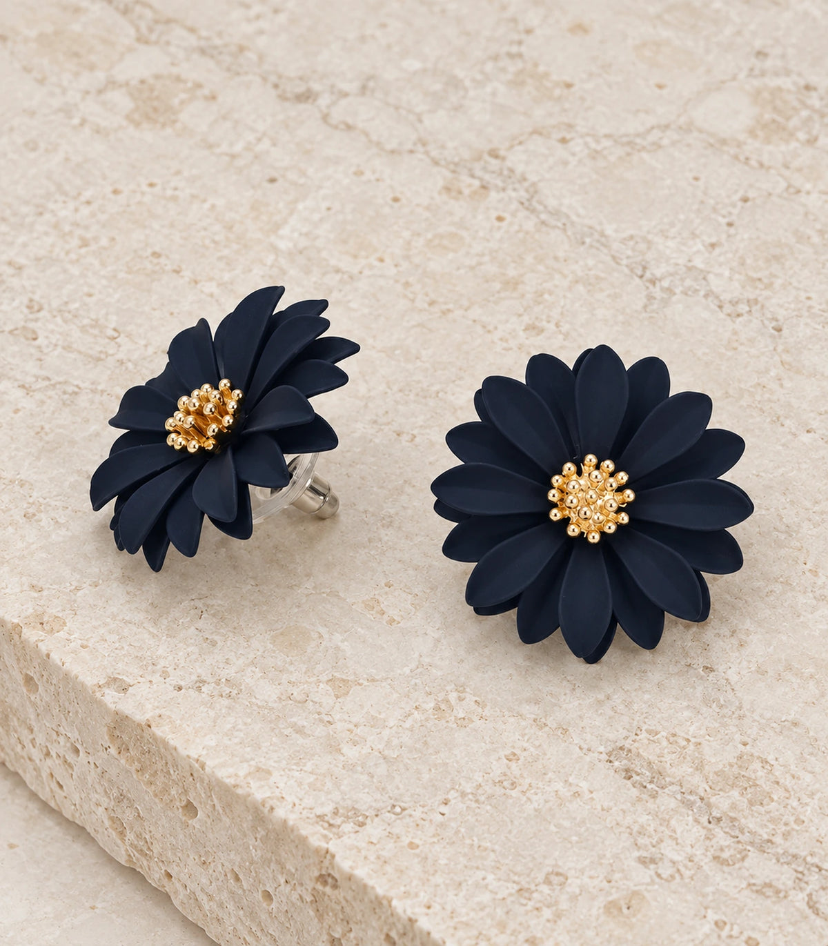 JIMIKI Navy layered starburst daisy stud earrings, matching pair in a styled flat lay #color_navy