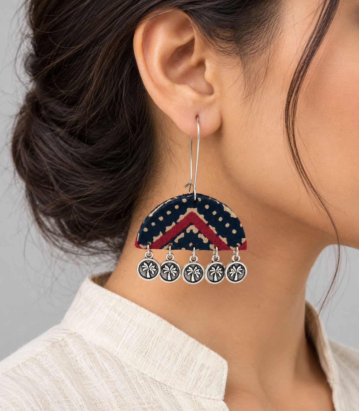 Worn closeup of navy and maroon chevron fabric earring and coin drops