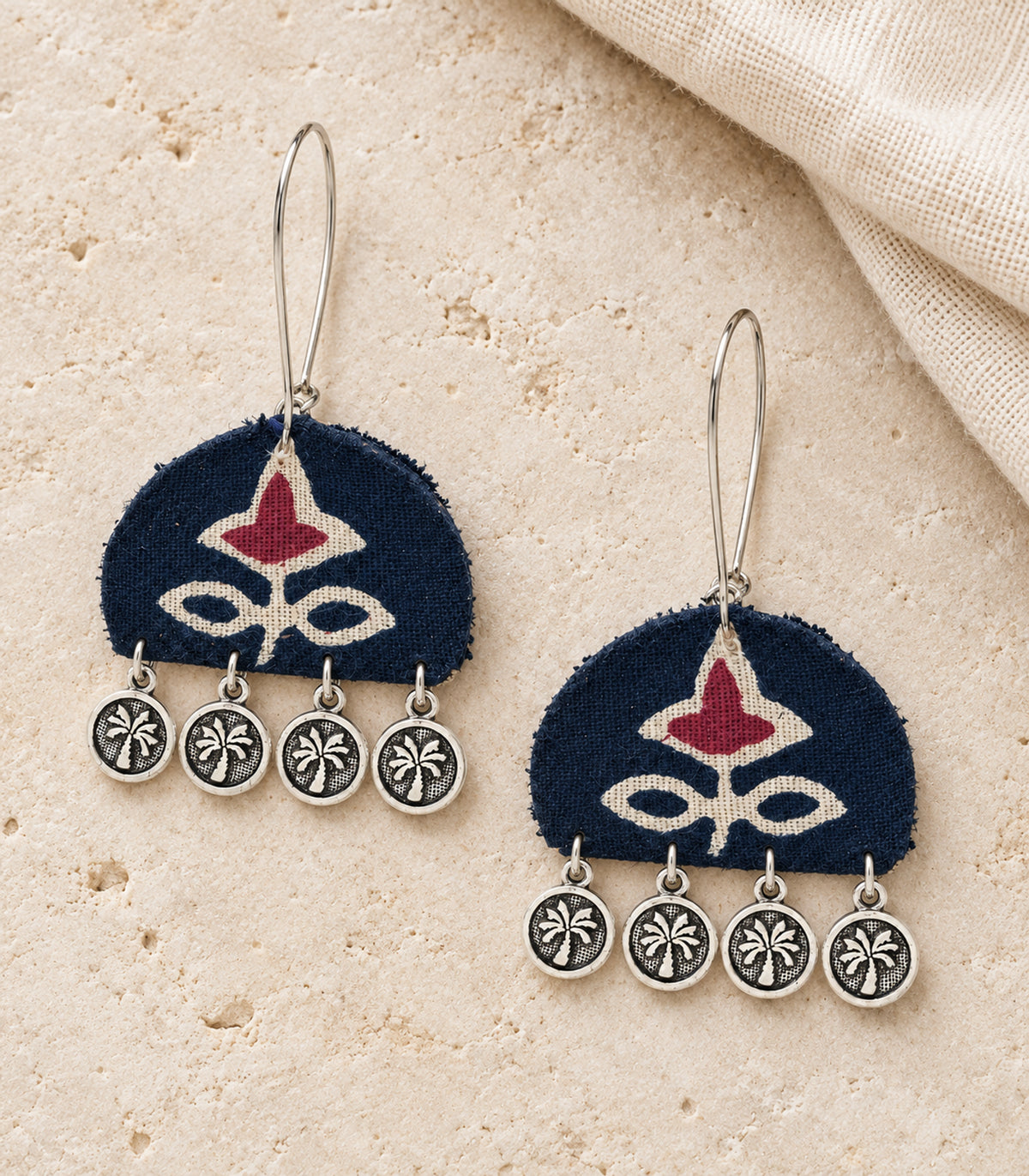 Navy and maroon floral coin drop earrings — editorial flatlay view