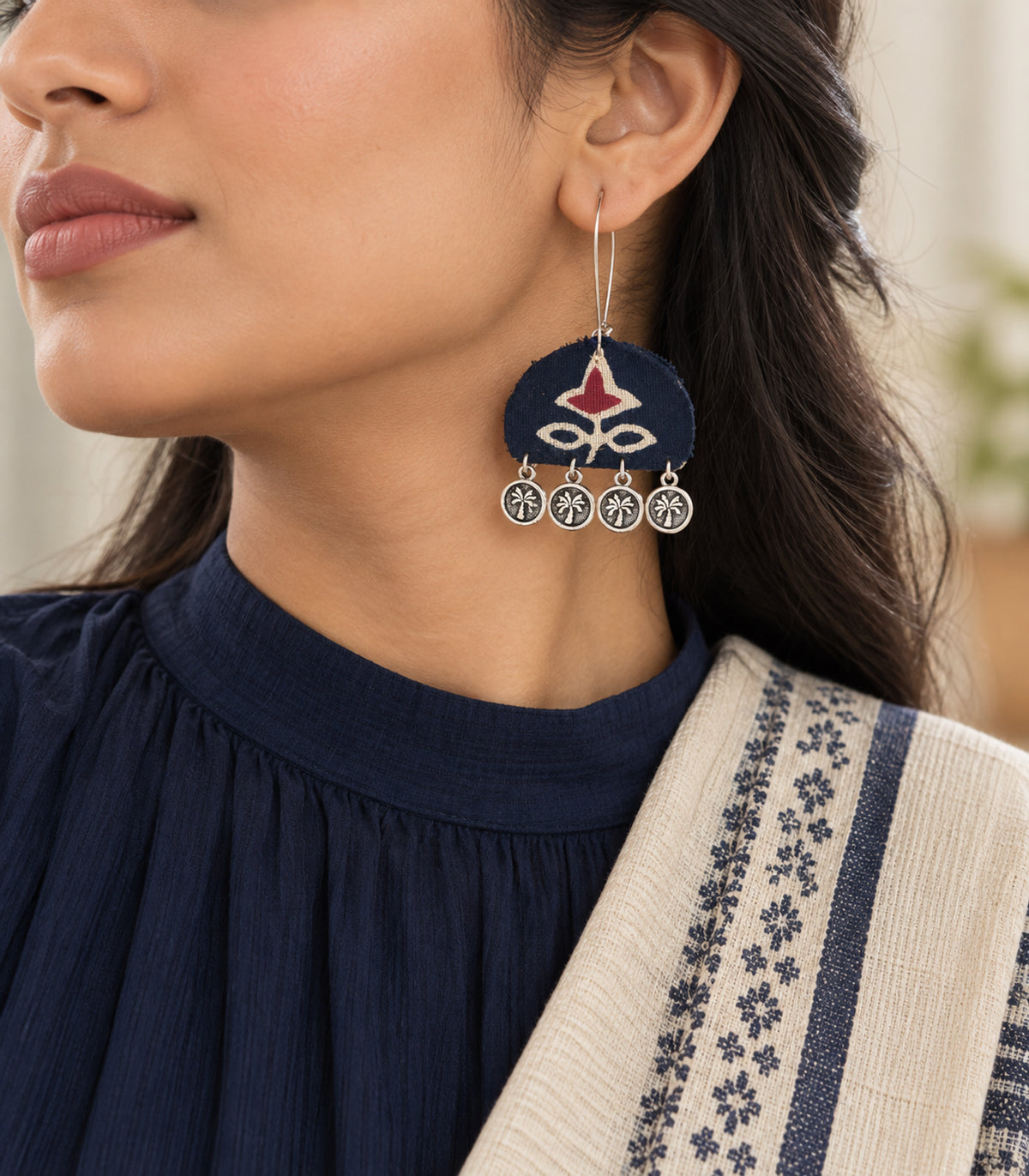 Navy and maroon floral coin drop earrings — editorial model view