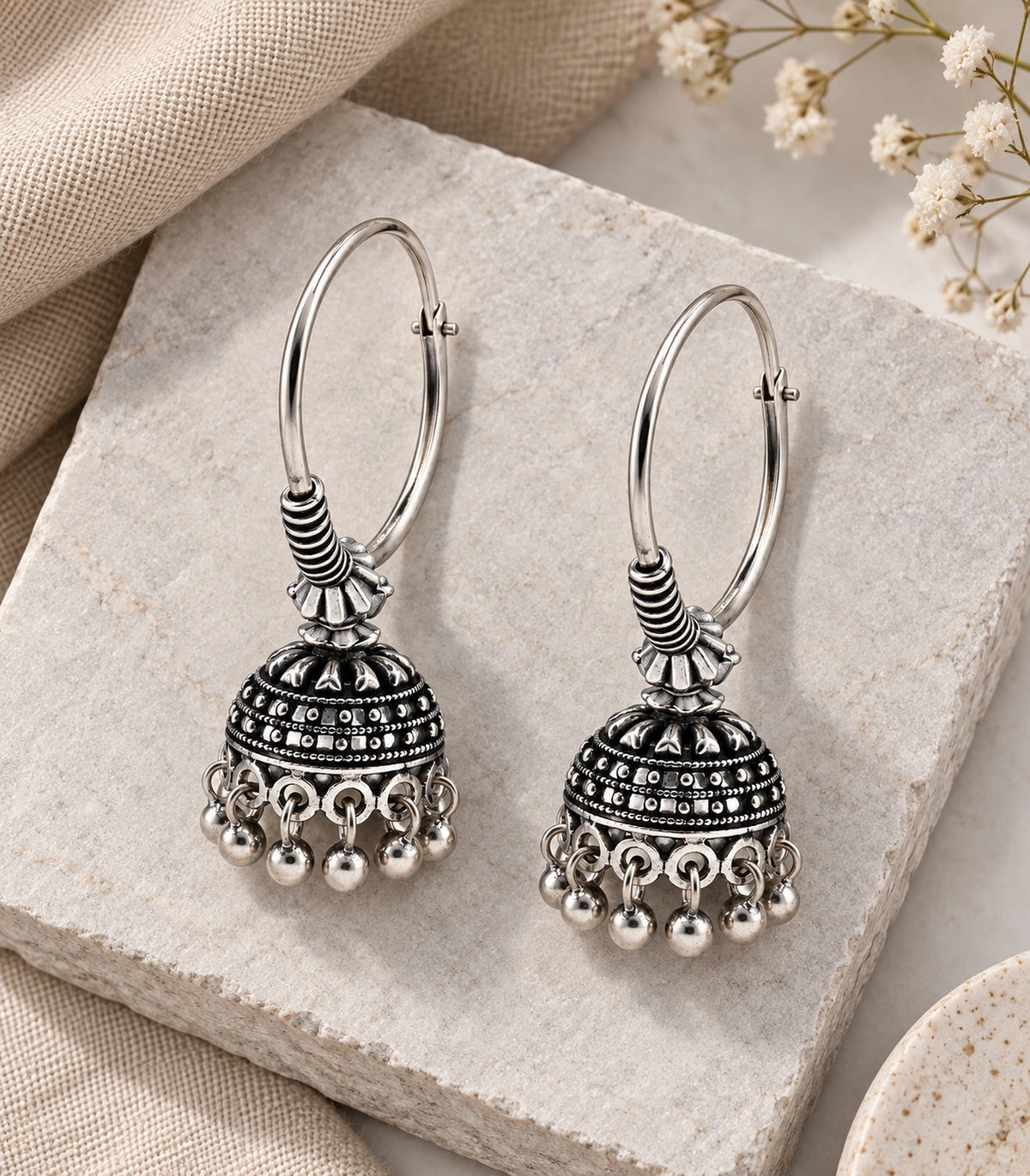 JIMIKI Oxidized Silver Beaded Hoop Jhumka Earrings - styled pair with textured fabric #color_oxidized-silver