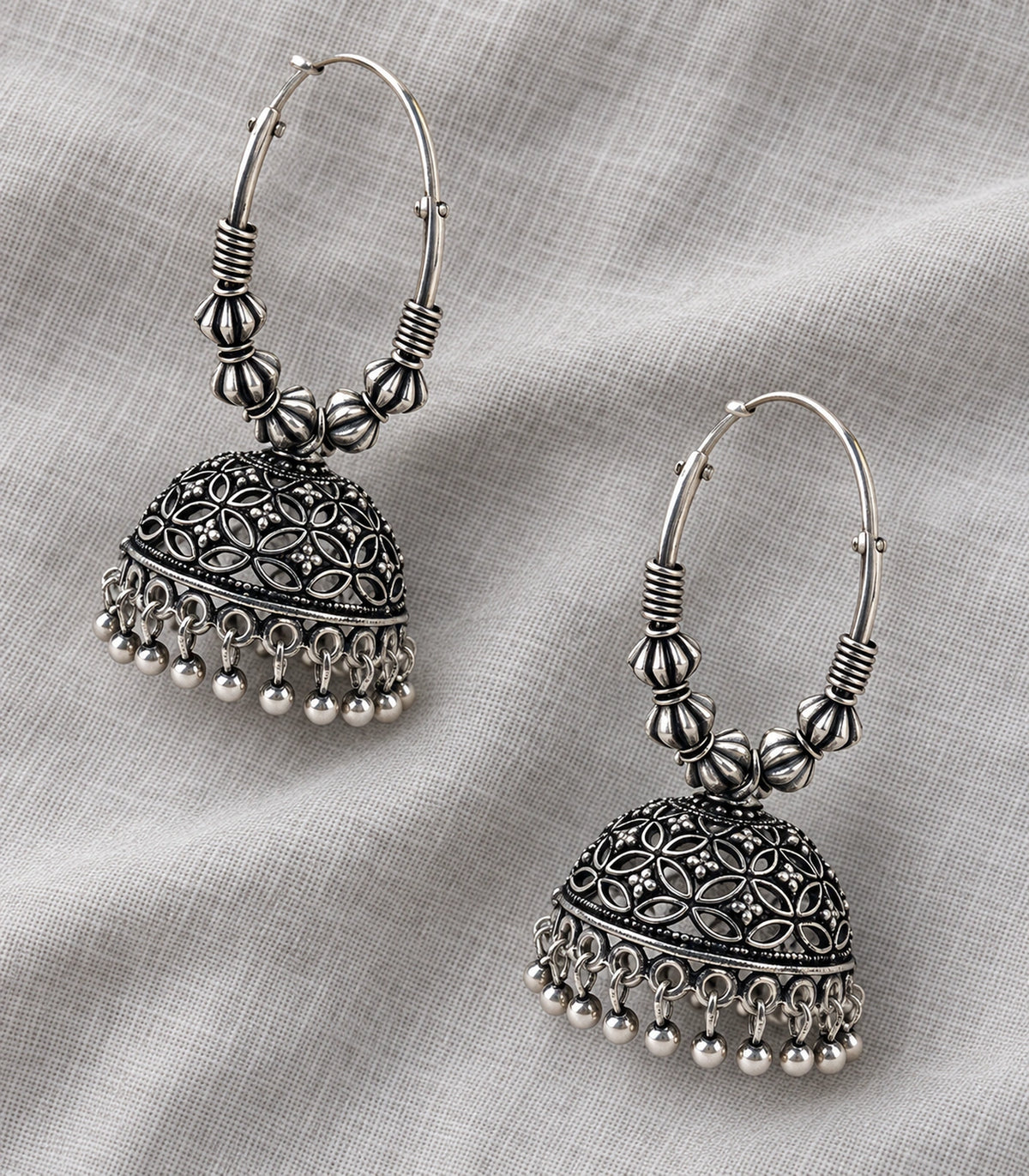 JIMIKI Oxidized Silver Floral Lattice Hoop Jhumka Earrings - Oxidized Silver pair in a styled flatlay #color_oxidized-silver