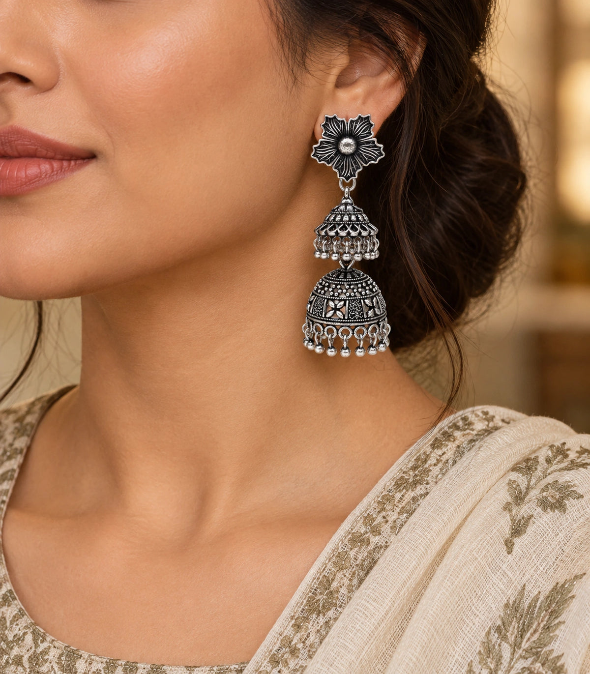 JIMIKI Oxidized Silver Hibiscus Double Jhumka Earrings - editorial styling with a cream embroidered outfit #color_oxidized-silver