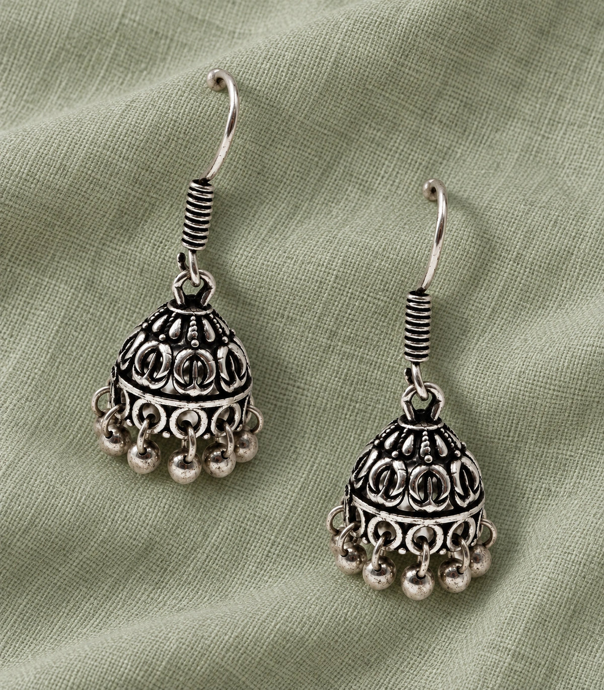 JIMIKI Oxidized Silver Leaf Motif Mini Jhumka Earrings - styled flatlay of the matching earrings #color_oxidized-silver
