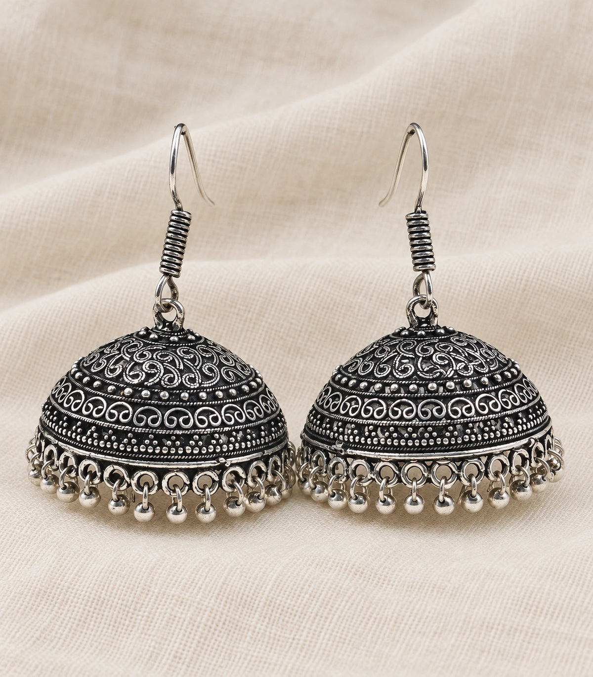 JIMIKI Oxidized Silver Scroll Dome Hook Jhumka Earrings - Oxidized Silver styled flatlay of the matching earrings #color_oxidized-silver