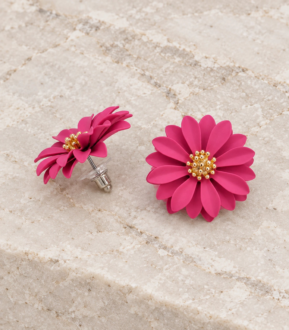 JIMIKI Pink layered starburst daisy stud earrings, matching pair in a styled flat lay #color_pink