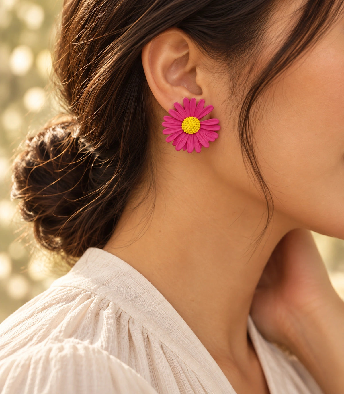 JIMIKI Pink yellow centre daisy stud earrings, earring worn in a warm editorial setting #color_pink