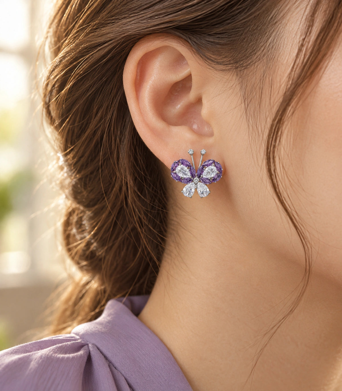 JIMIKI Crystal Butterfly Stud Earring Pair in Purple / silver tone, editorial model view #color_purple / silver tone