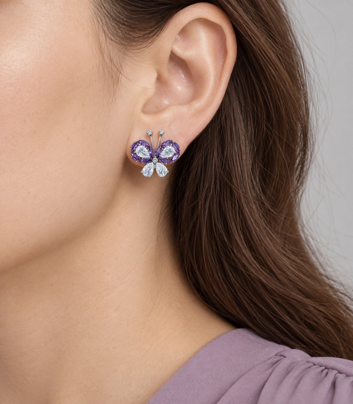 JIMIKI Crystal Butterfly Stud Earring Pair in Purple / silver tone, model wearing view #color_purple / silver tone