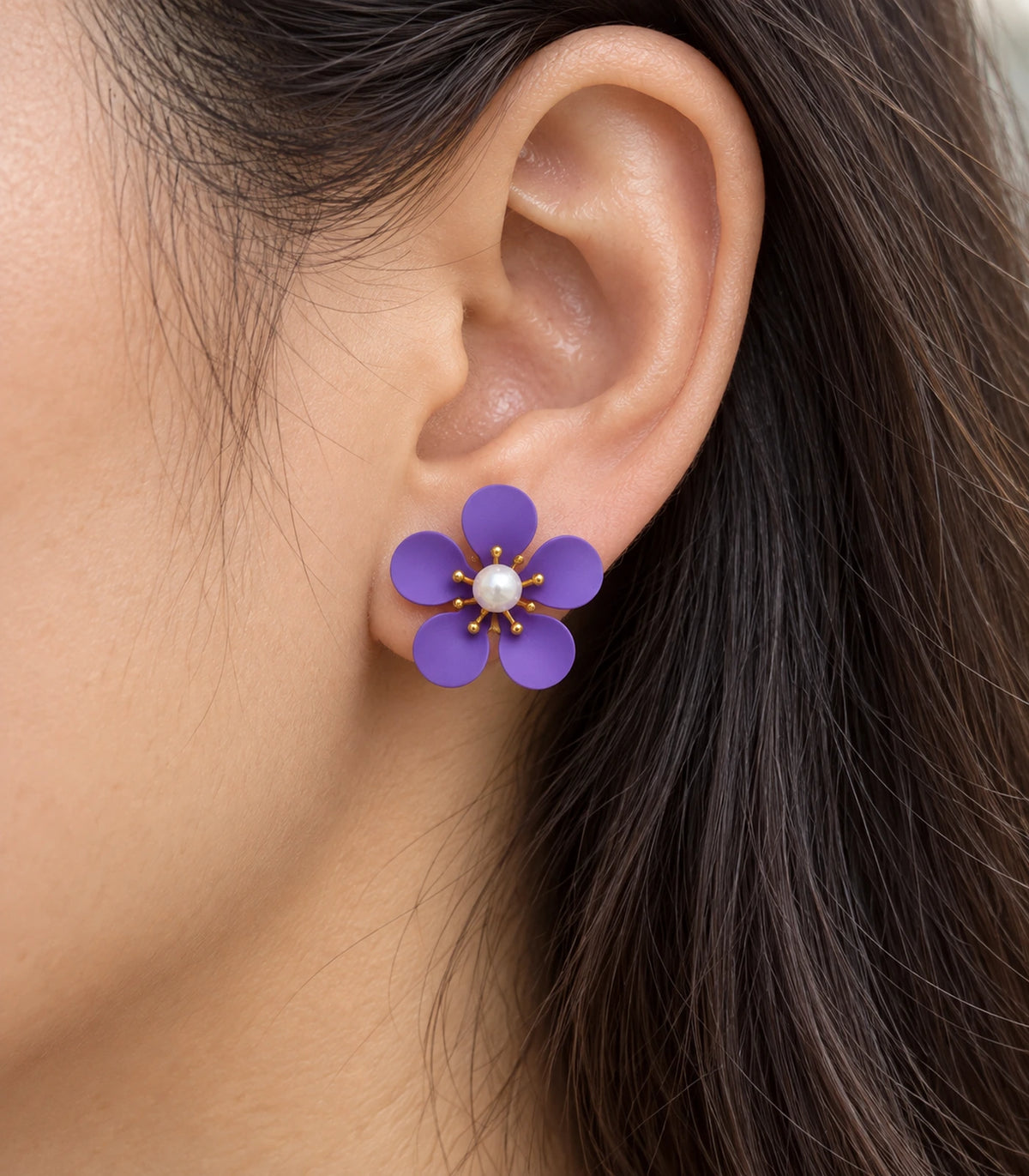 JIMIKI purple five-petal flower stud earrings with pearl-effect centre, closeup of flower stud in a natural worn setting #color_purple