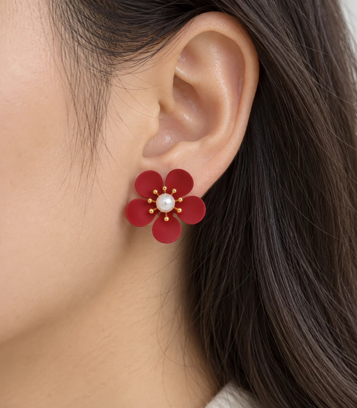 Red five-petal pearl flower stud earrings close-up