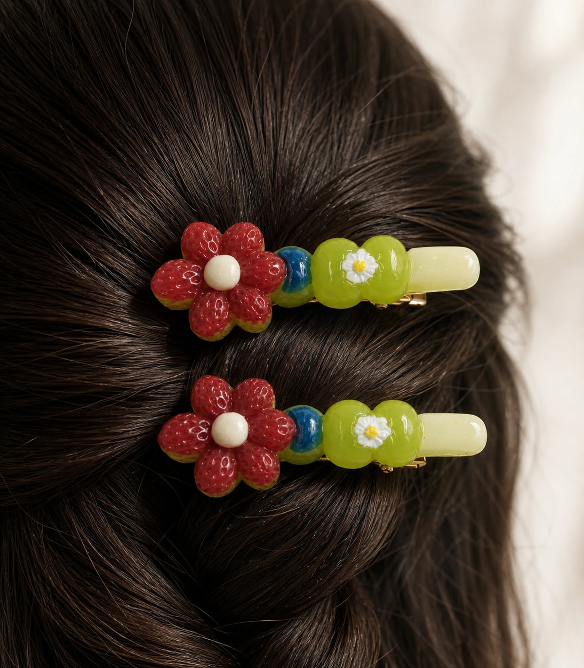 Close-up of the Red Flower Green Daisy Barrette Pair details