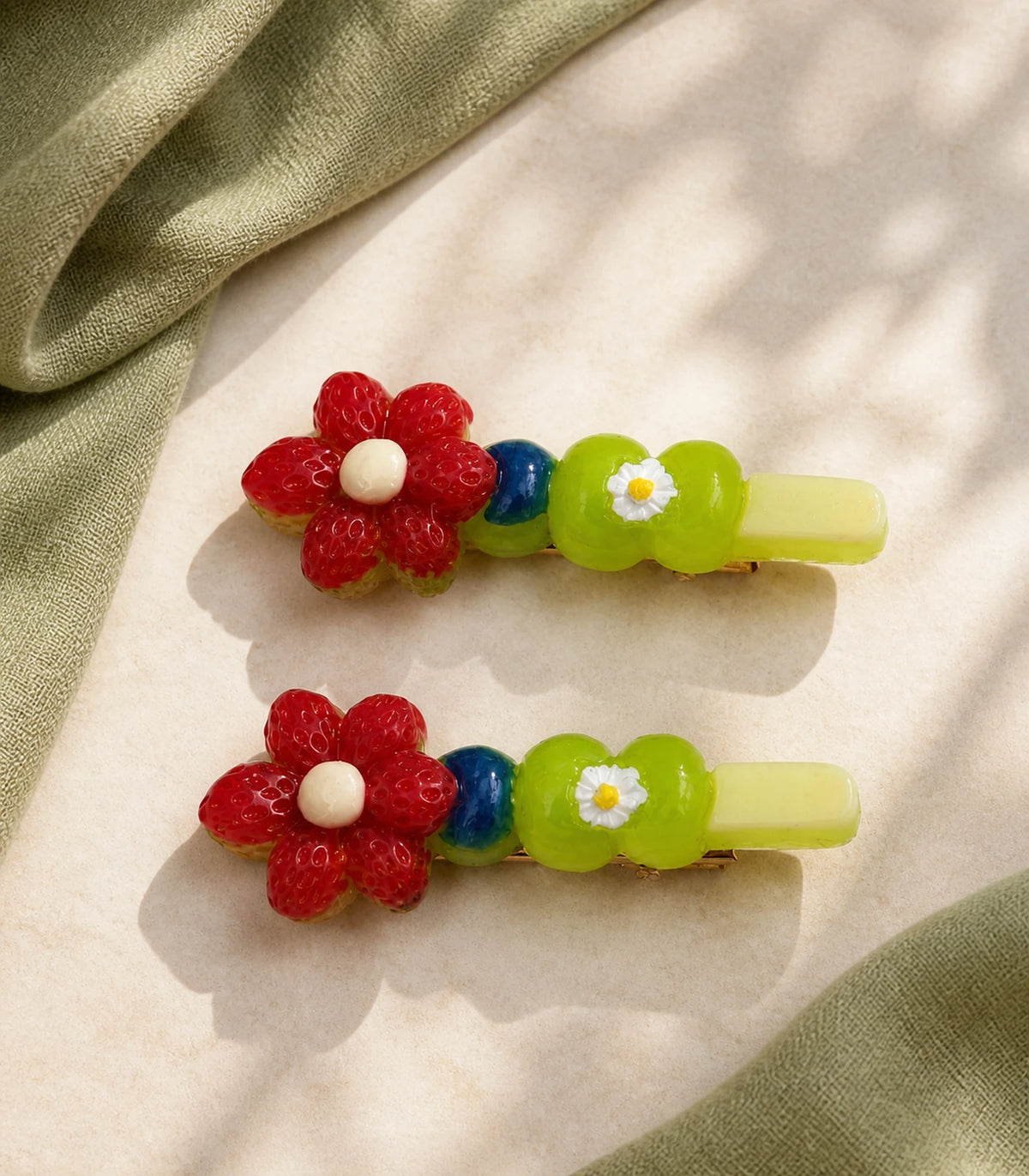 Editorial flat lay of the Red Flower Green Daisy Barrette Pair
