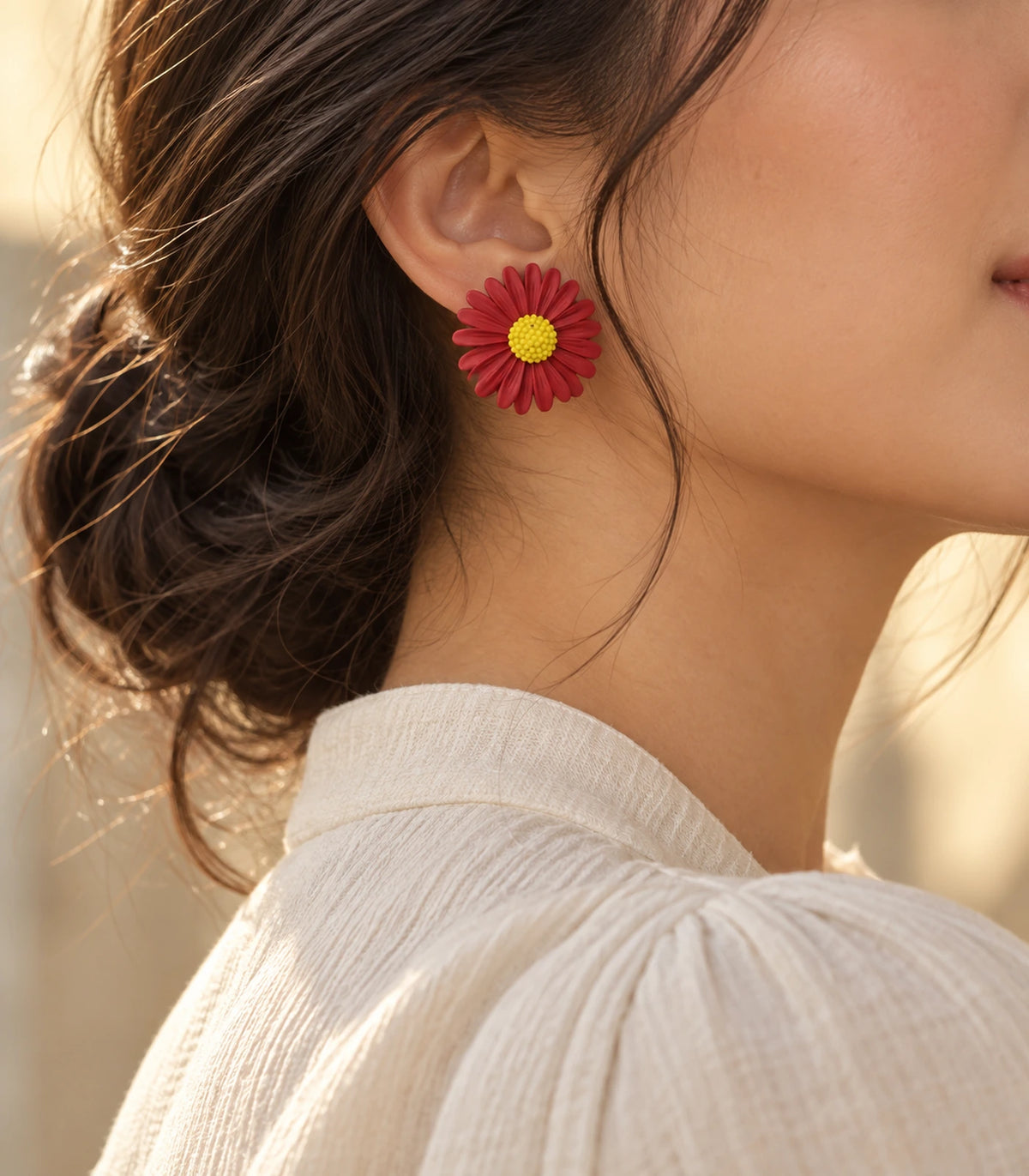 JIMIKI Red yellow centre daisy stud earrings, earring worn in a warm editorial setting #color_red