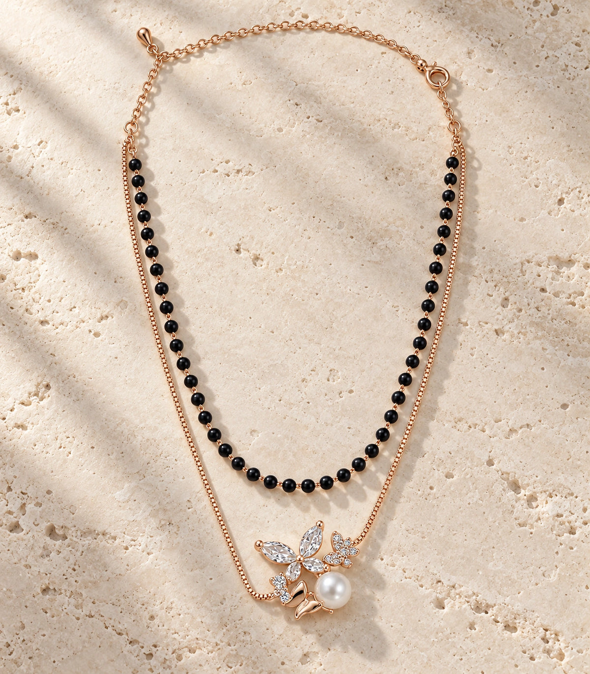 JIMIKI Rose-Gold Black-Bead Crystal-Butterfly Pearl Layered Necklace in Rose Gold / Black - editorial flatlay #color_rose-gold-black