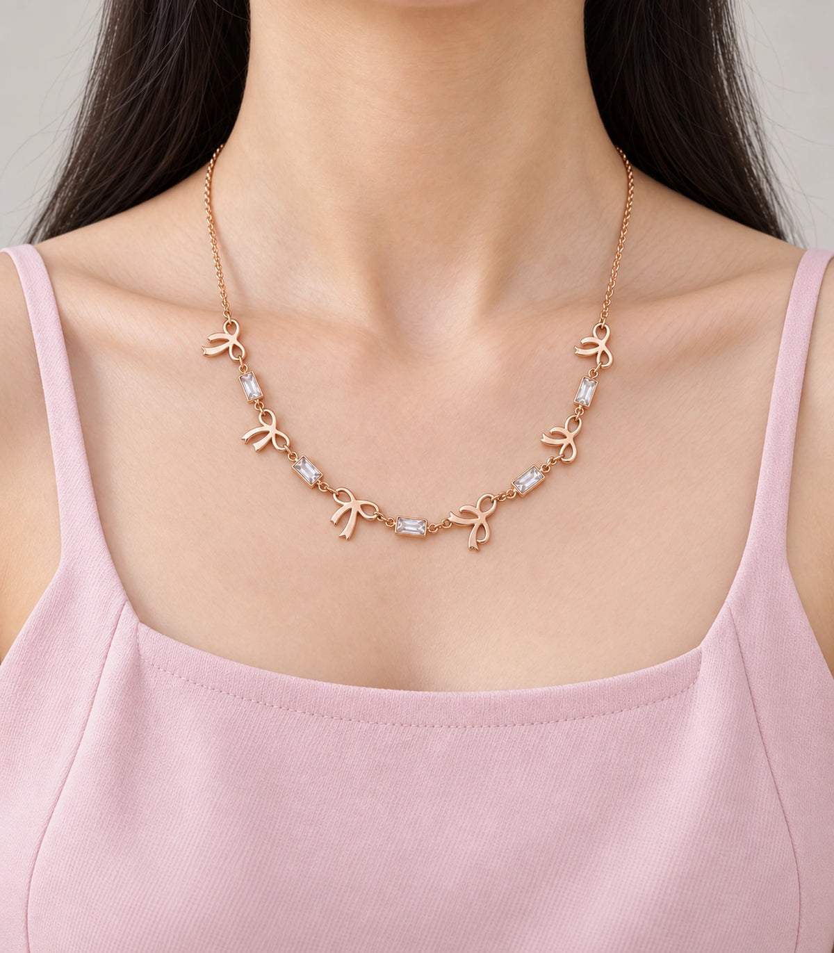 JIMIKI Rose Gold Bow Baguette Crystal Necklace in Rose Gold - worn styling view #color_rose-gold