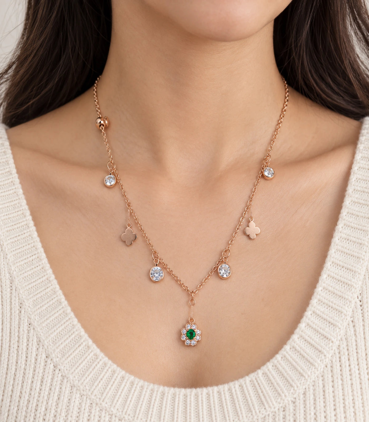 JIMIKI Rose Gold green flower and clover charm necklace, worn close-up of green-centred flower and round sparkling charms #color_rose gold