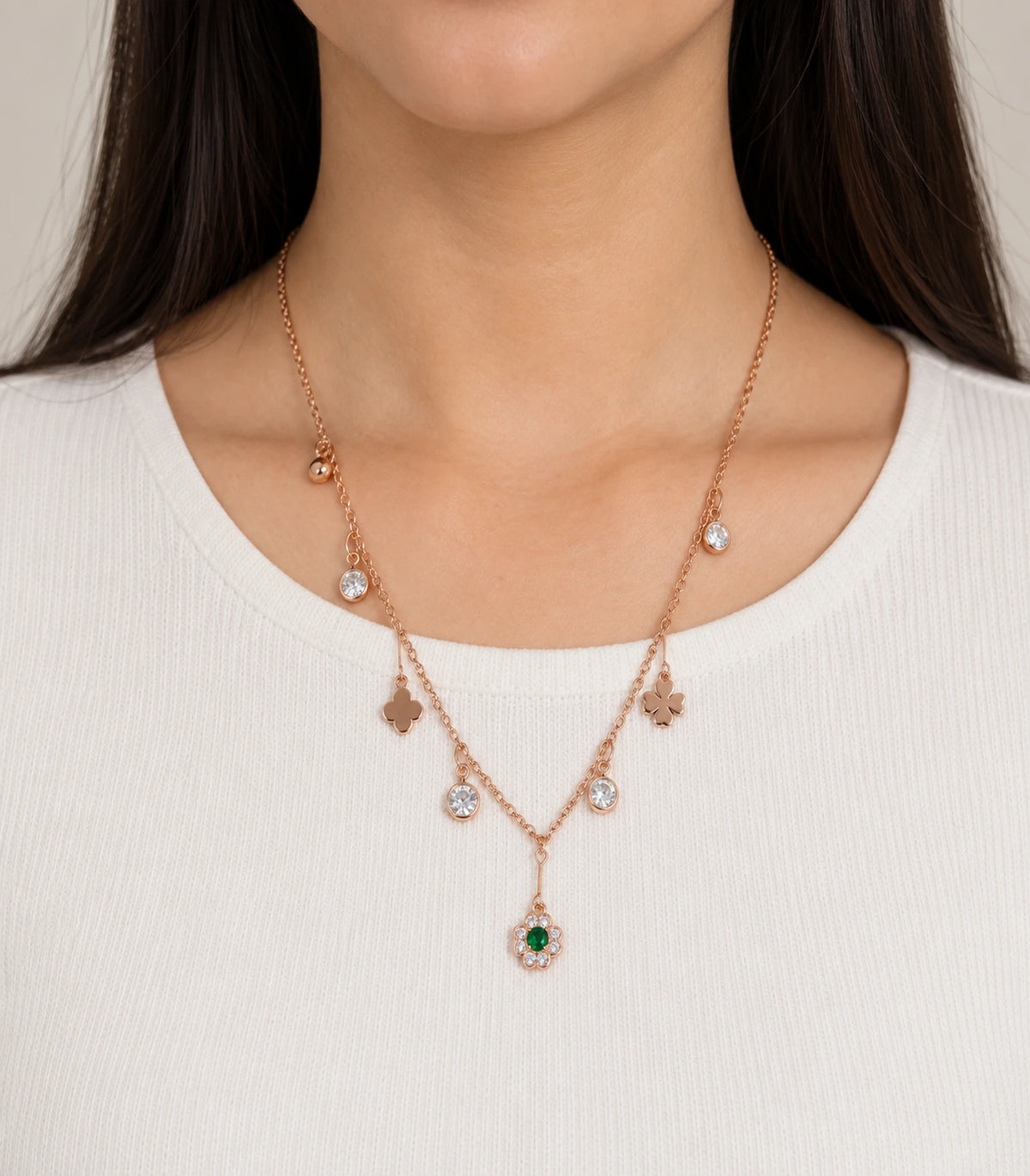 JIMIKI Rose Gold green flower and clover charm necklace, worn with a plain cream top #color_rose gold