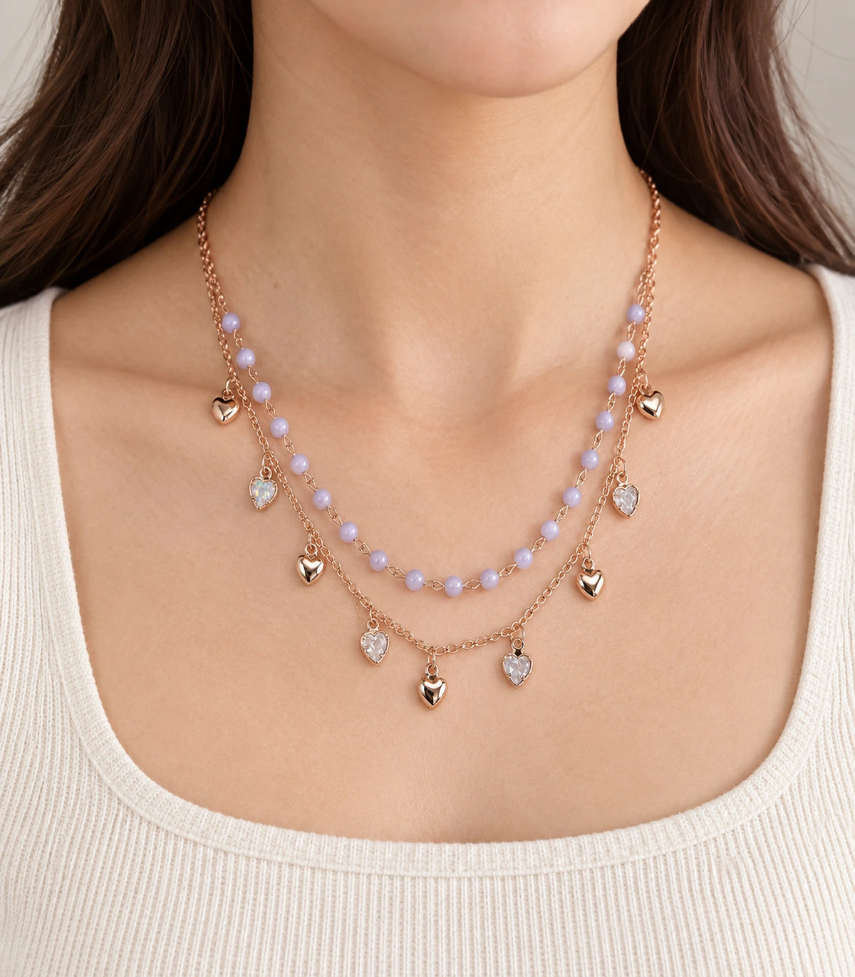 JIMIKI Rose Gold Lavender Bead Heart Charm Layered Necklace - close-up of the worn lavender beads and heart charms #color_rose-gold