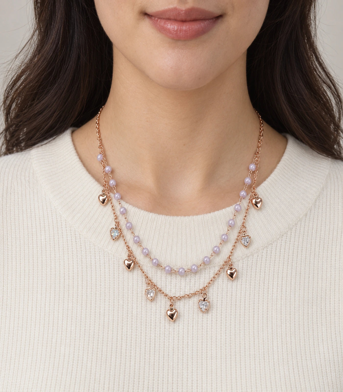 JIMIKI Rose Gold Lavender Bead Heart Charm Layered Necklace - layered necklace worn with a cream top #color_rose-gold
