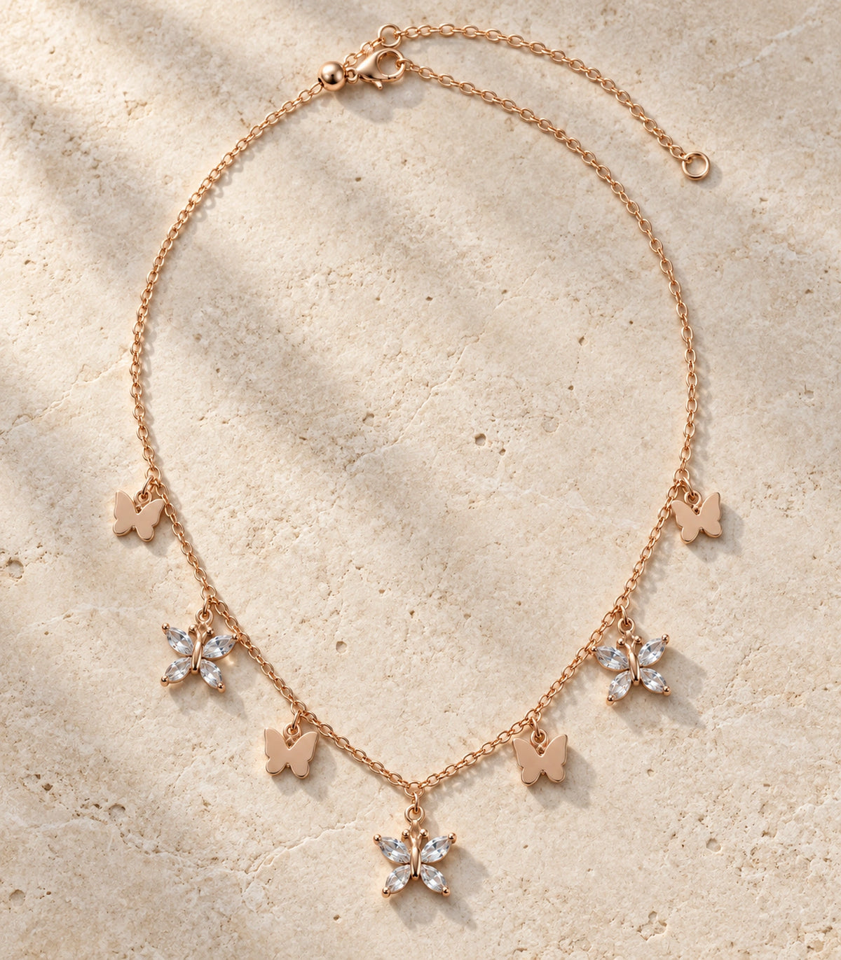 JIMIKI Rose Gold Mixed Butterfly Charm Necklace in Rose Gold - editorial flatlay #color_rose-gold