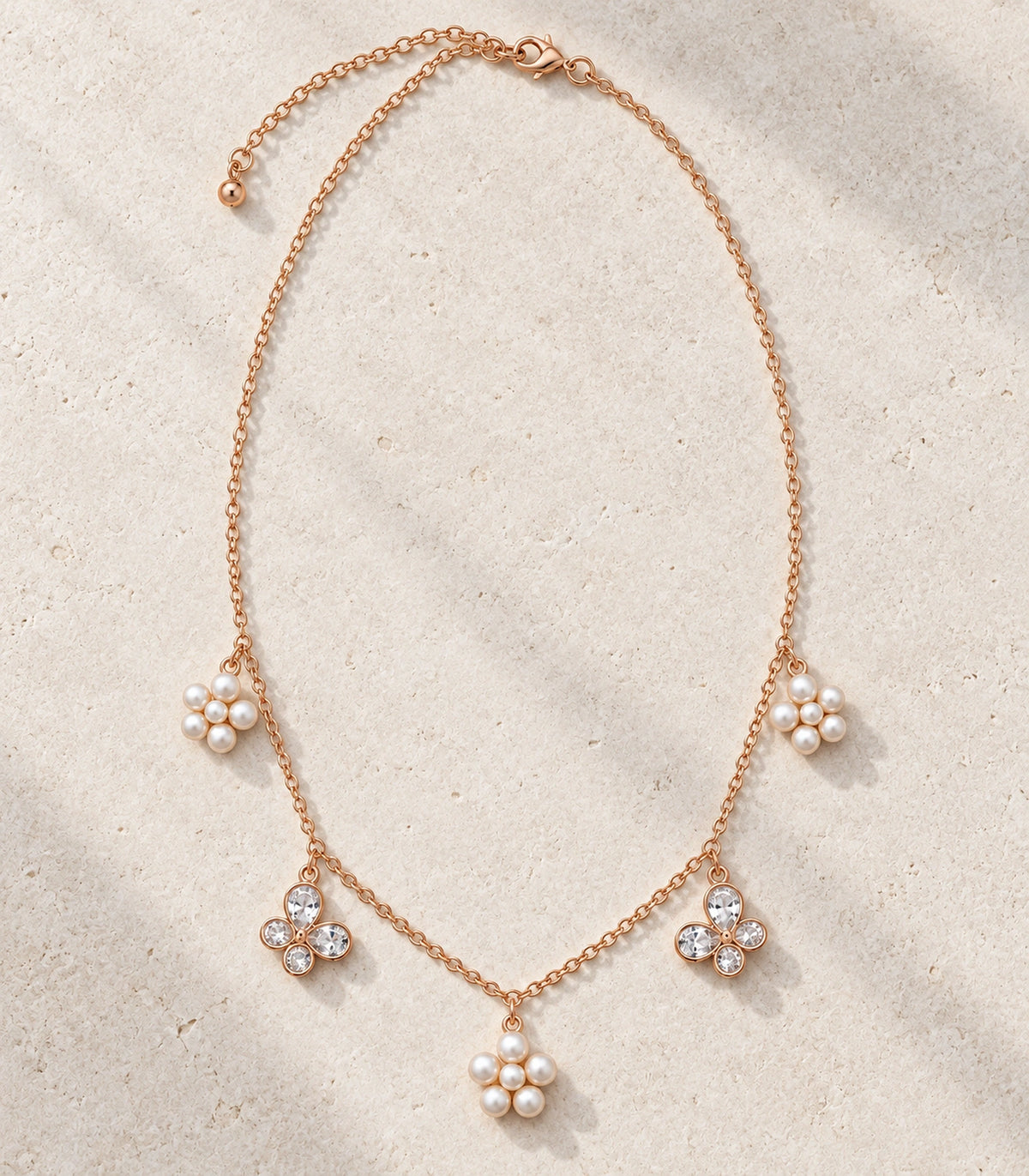 JIMIKI Rose Gold Pearl Flower Crystal Butterfly Necklace in Rose Gold - editorial flatlay #color_rose-gold
