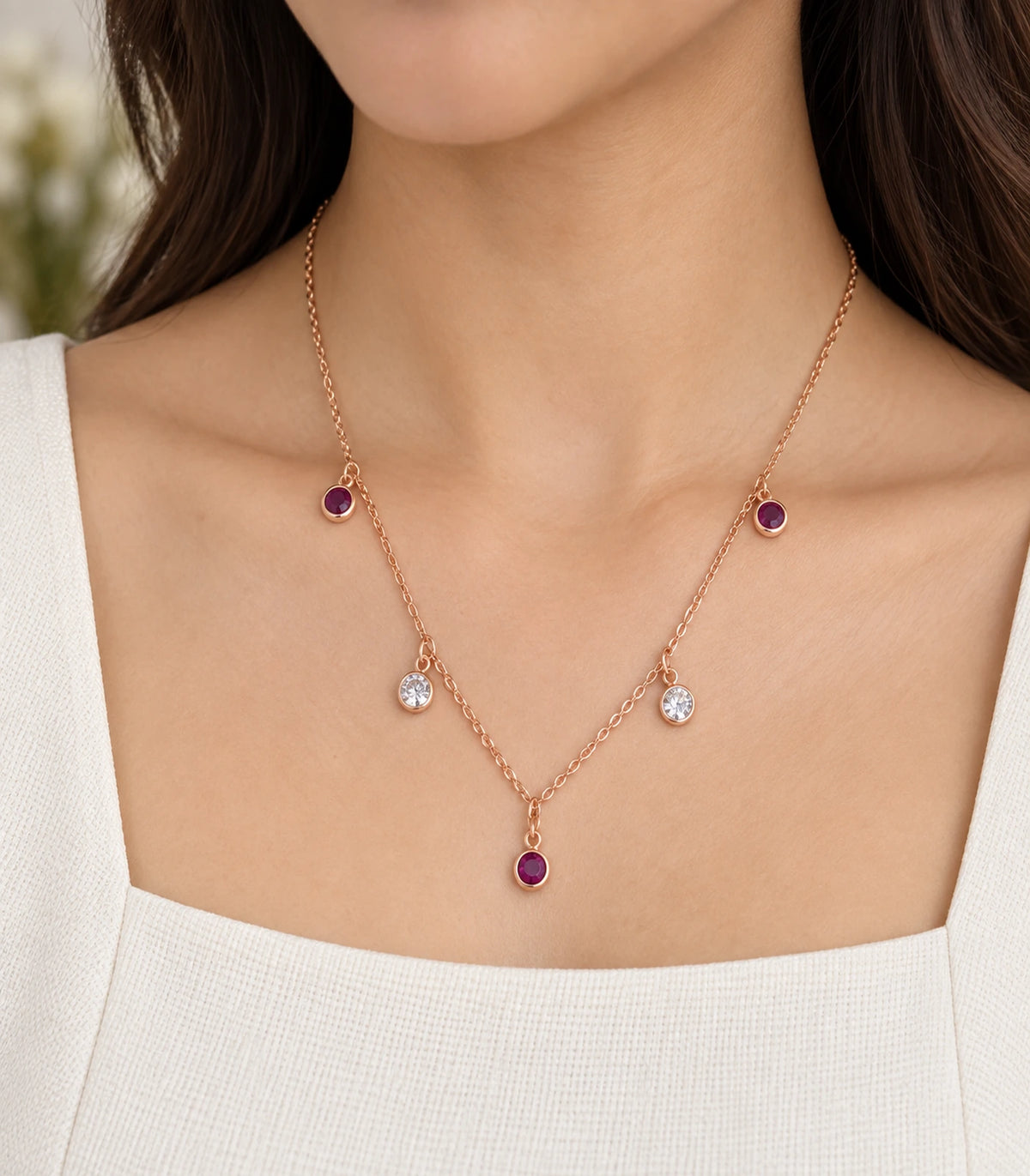 JIMIKI Purple and Clear Five-Stone Station Necklace in rose-gold tone, worn close-up showing the five round drops #color_purple & clear
