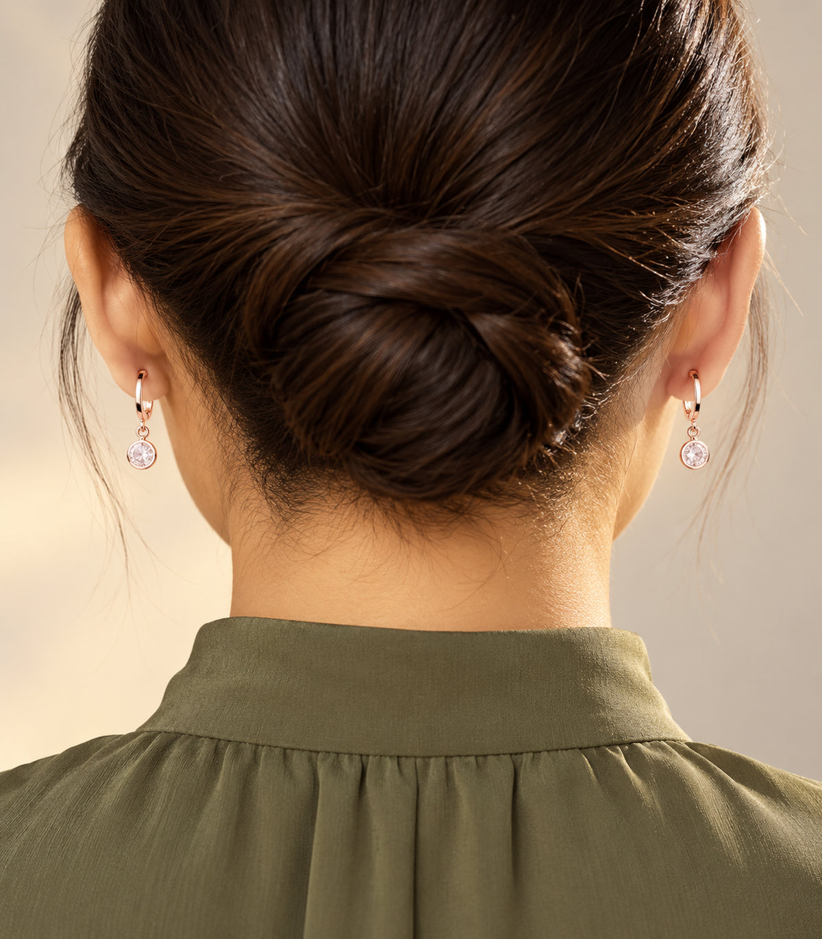 Rose gold tone hoop earring pair from the three-pair set, editorial worn view