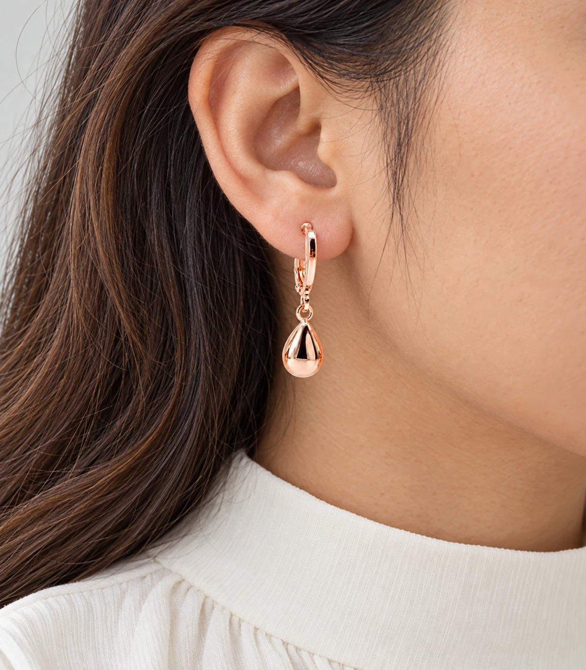 Rose gold tone puffed teardrop hoop earring closeup
