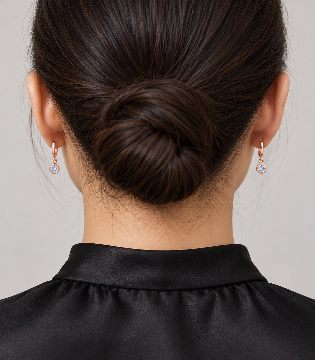 Rose gold tone hoop earrings shown worn