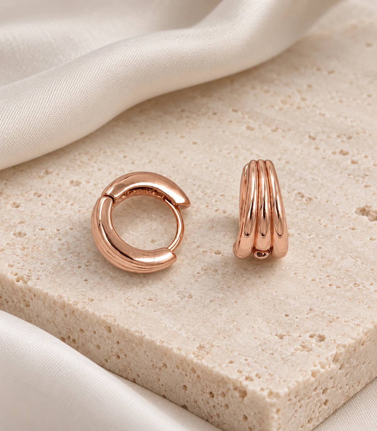 JIMIKI Triple-Ridge Huggie Hoop Earrings in Rose Gold Tone - editorial-flatlay #color_rose-gold-tone