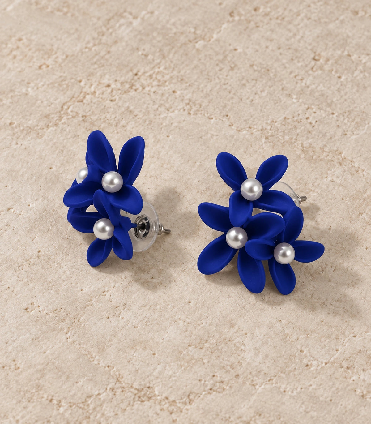 JIMIKI Royal Blue cascading floral cluster stud earrings, matching pair styled on a light textured surface #color_royal blue