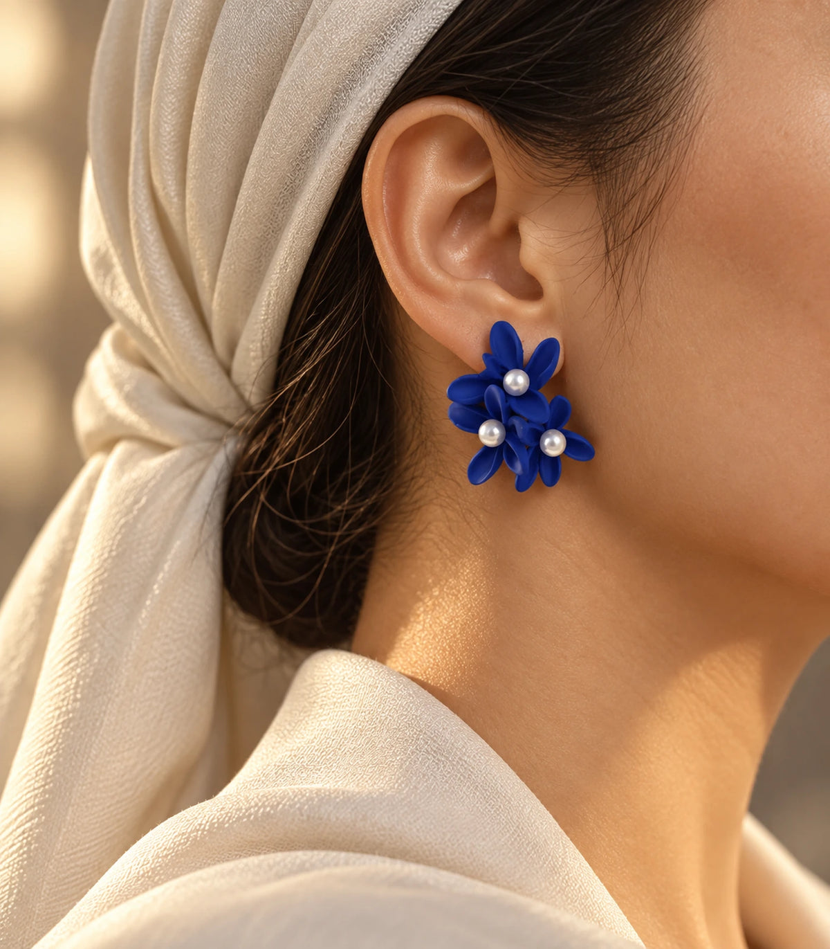 JIMIKI Royal Blue cascading floral cluster stud earrings, worn with softly lit editorial styling #color_royal blue